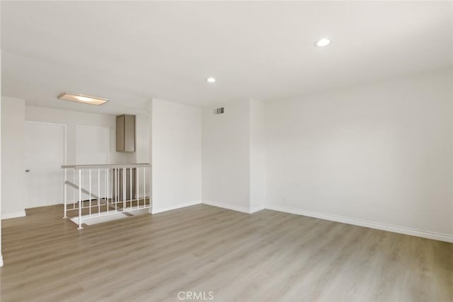 unfurnished room featuring recessed lighting, visible vents, light wood-style flooring, and baseboards