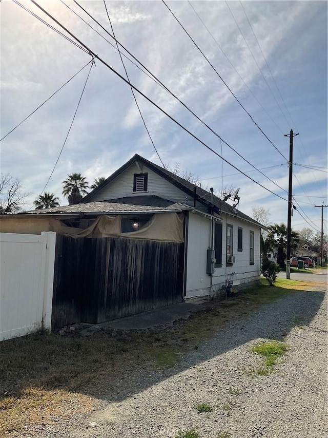 view of side of property featuring driveway and fence