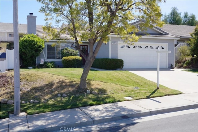 view of front facade with a front lawn, concrete driveway, an attached garage, and a tiled roof