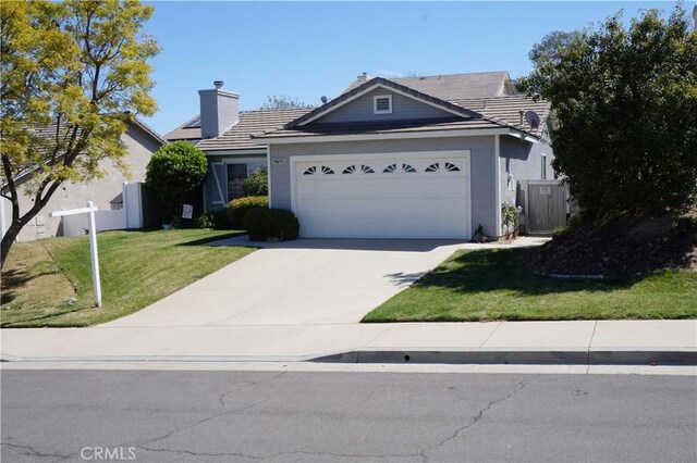 ranch-style home with a garage, concrete driveway, a front yard, and fence