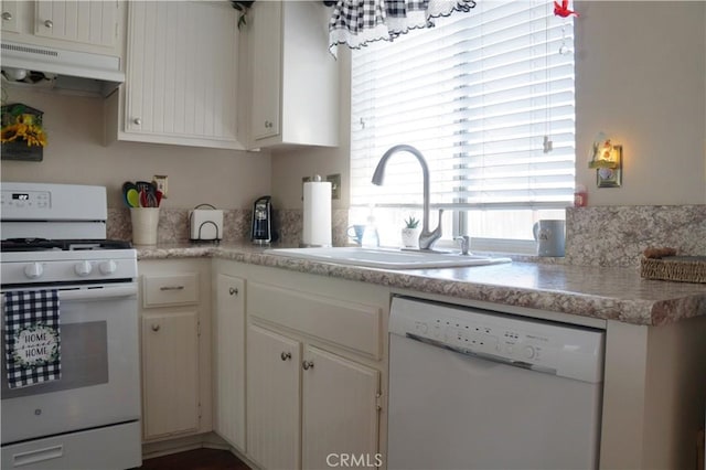 kitchen with under cabinet range hood, white appliances, light countertops, and a sink