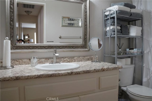 bathroom with visible vents, toilet, and vanity