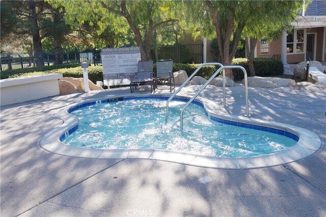 view of swimming pool featuring fence