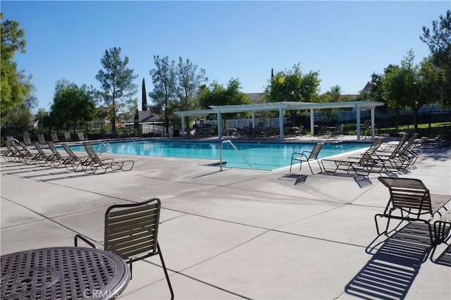 community pool with a patio area, fence, and a pergola