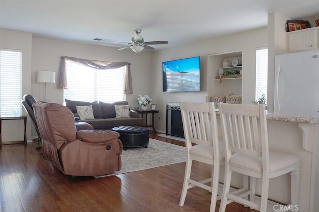 living area with dark wood finished floors and ceiling fan