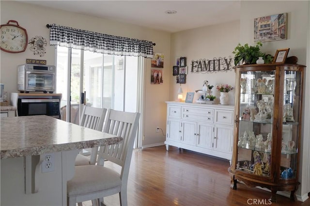 dining room with dark wood-type flooring and baseboards