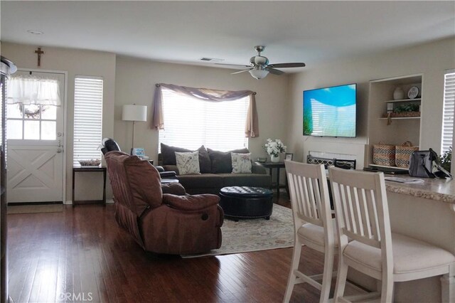 living room featuring visible vents, a ceiling fan, and hardwood / wood-style flooring