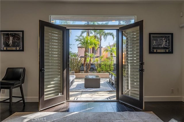 doorway to outside with baseboards and wood finished floors