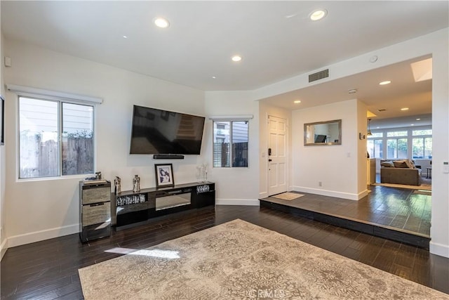 living area featuring recessed lighting, visible vents, wood-type flooring, and baseboards