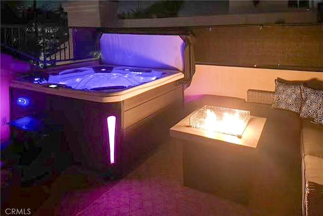 view of patio / terrace with a covered hot tub and an outdoor fire pit