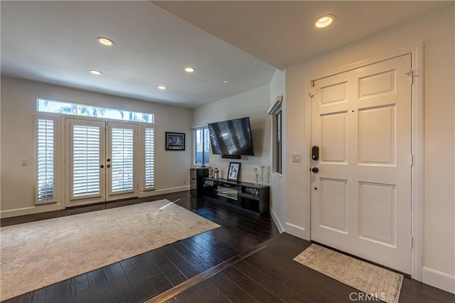 foyer with recessed lighting, a healthy amount of sunlight, dark wood-style flooring, and baseboards