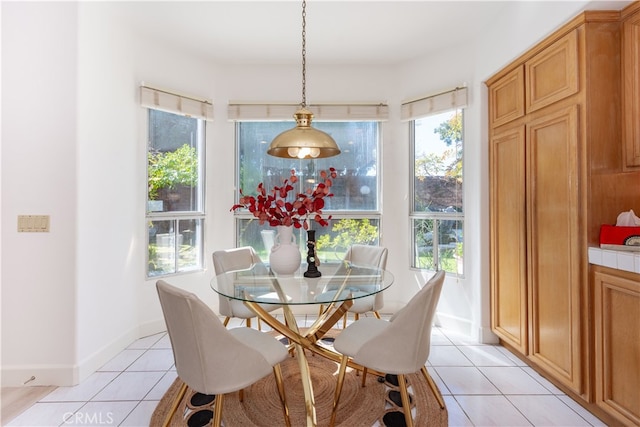 dining space with light tile patterned floors, a healthy amount of sunlight, and baseboards