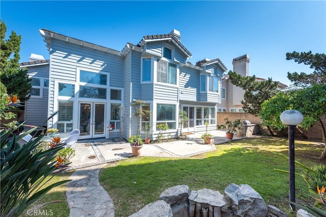 back of house featuring french doors, fence, a yard, and a patio area