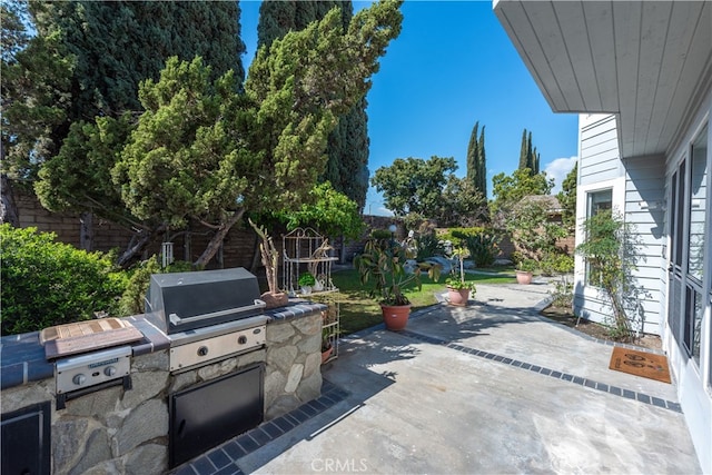 view of patio / terrace with a grill, an outdoor kitchen, and fence