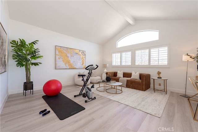 exercise area featuring high vaulted ceiling, baseboards, and light wood-style floors