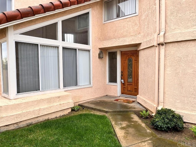 view of exterior entry featuring stucco siding