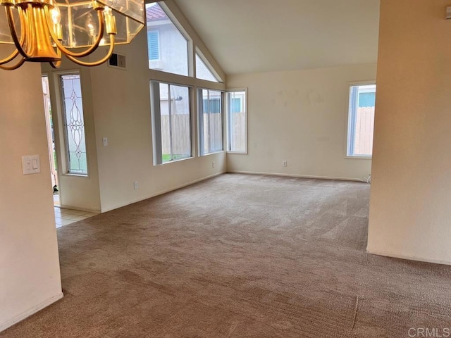 carpeted spare room featuring visible vents, high vaulted ceiling, a chandelier, and tile patterned flooring