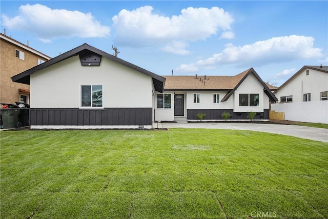 back of house featuring a yard and stucco siding