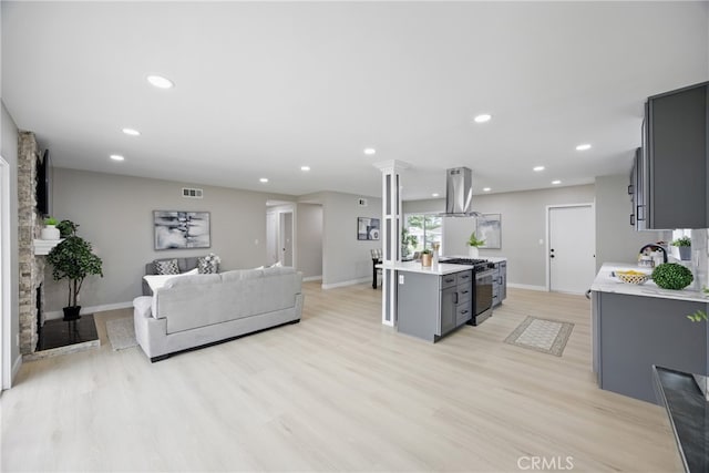 living area featuring a fireplace, light wood-style flooring, recessed lighting, and visible vents