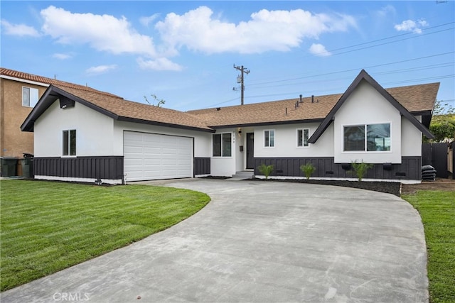 view of front of home with a front lawn, concrete driveway, roof with shingles, stucco siding, and an attached garage