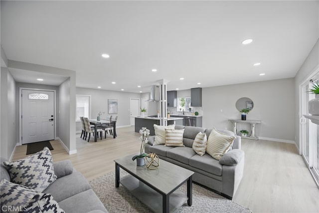 living room with recessed lighting, light wood-style floors, and baseboards