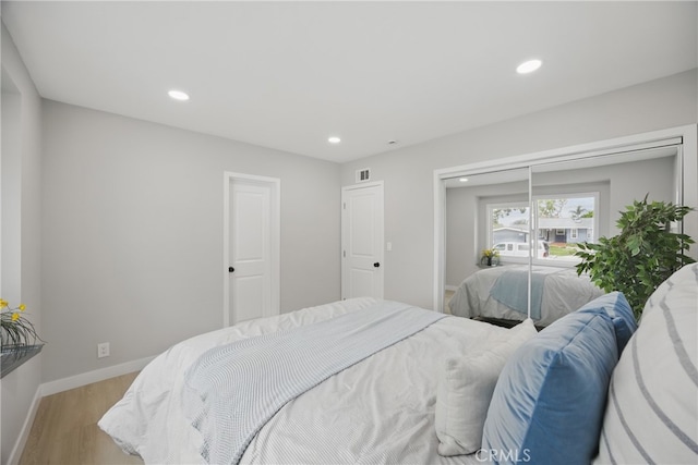 bedroom featuring light wood-style flooring, recessed lighting, visible vents, and baseboards