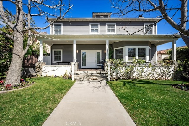 american foursquare style home featuring a front lawn and covered porch