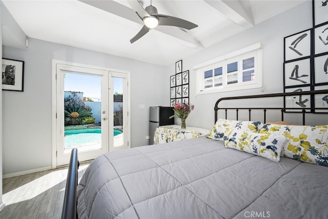 bedroom with access to outside, wood finished floors, freestanding refrigerator, french doors, and baseboards