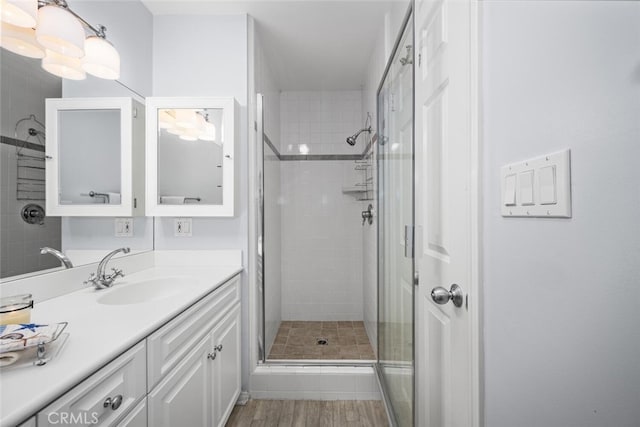 bathroom featuring vanity, wood finished floors, and a shower stall