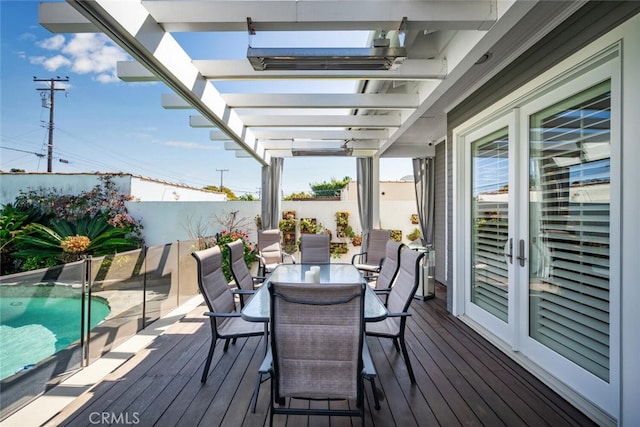 wooden deck with outdoor dining space, a fenced in pool, and a pergola