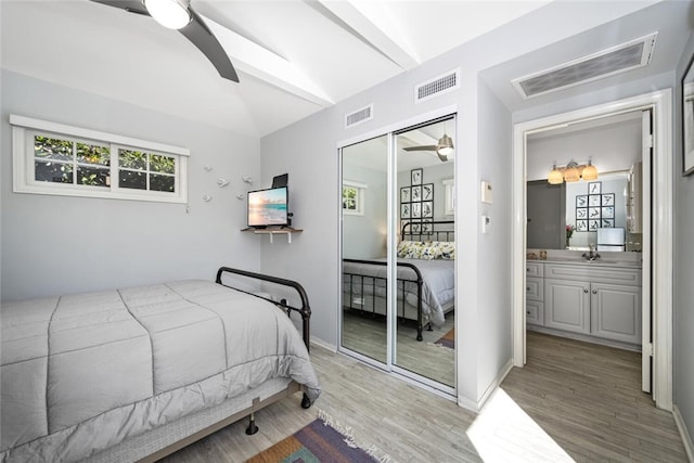 bedroom with a closet, visible vents, a sink, and wood finished floors