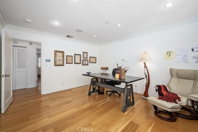 office with visible vents, light wood-style floors, and ornamental molding