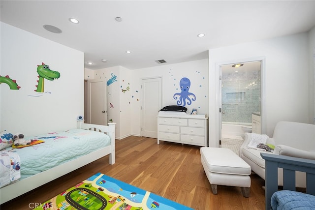 bedroom with recessed lighting, wood finished floors, visible vents, and connected bathroom