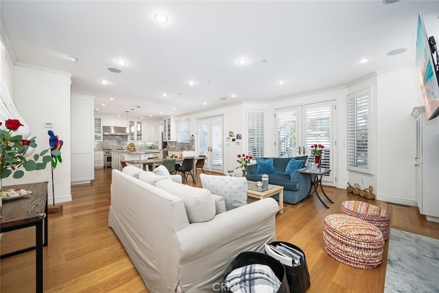 living room featuring crown molding, recessed lighting, and light wood finished floors