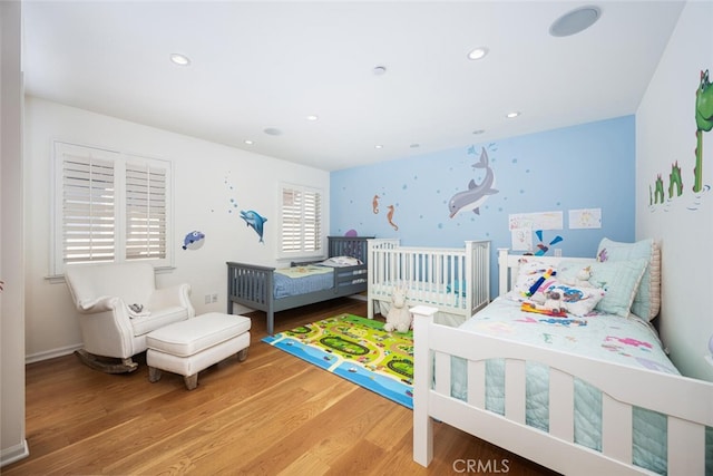 bedroom with recessed lighting and wood finished floors