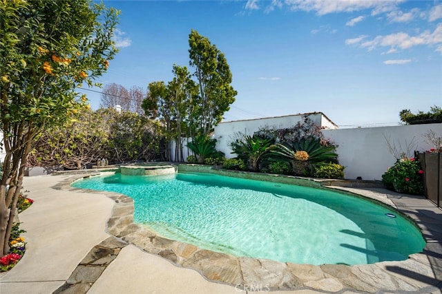 view of pool featuring a pool with connected hot tub, a fenced backyard, and a patio area