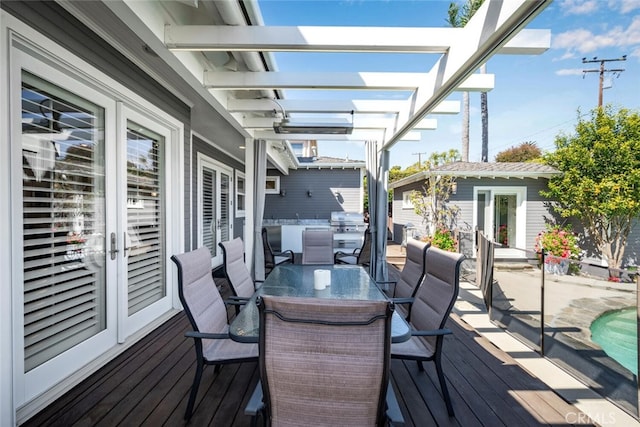 wooden deck with an outdoor structure, area for grilling, outdoor dining area, and a pergola