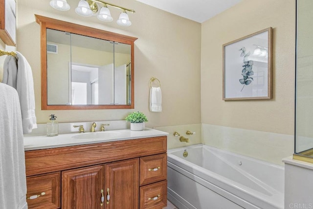 bathroom with a bath, visible vents, and vanity