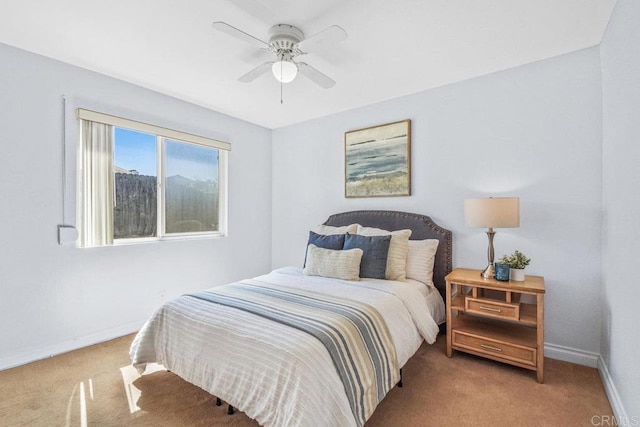 bedroom featuring baseboards, light colored carpet, and a ceiling fan