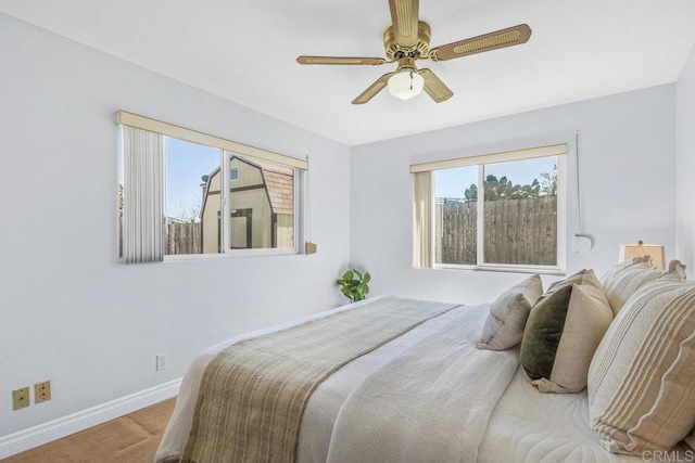 carpeted bedroom with a ceiling fan and baseboards