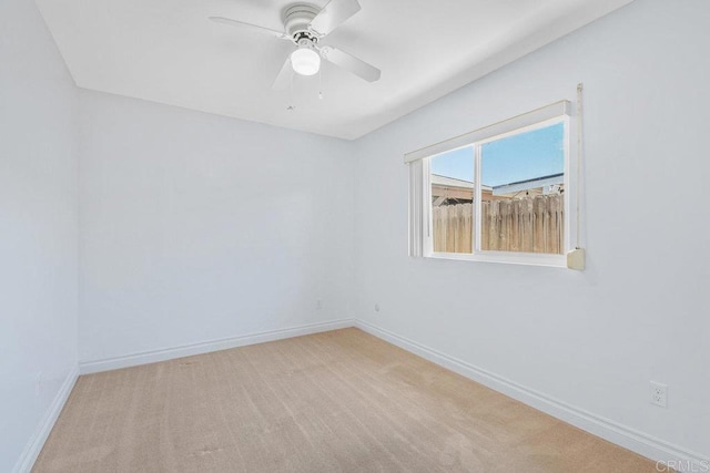 carpeted empty room with baseboards and ceiling fan