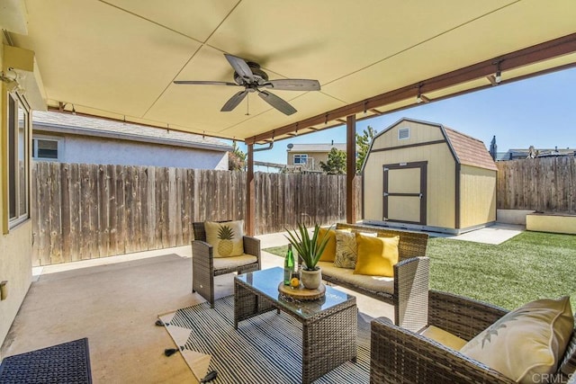 view of patio featuring a ceiling fan, an outdoor living space, a fenced backyard, a storage shed, and an outdoor structure