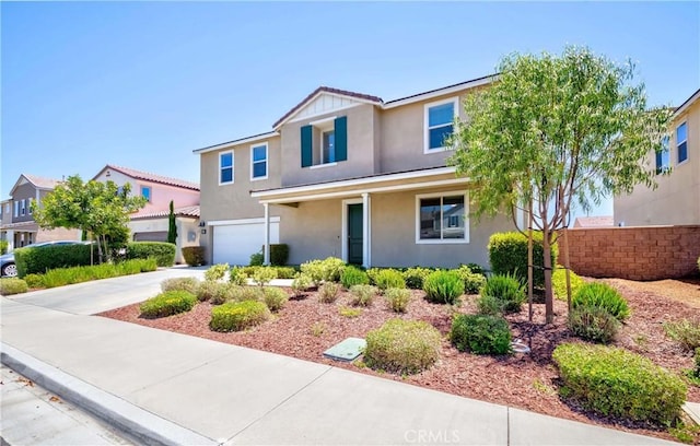 traditional-style house featuring stucco siding, concrete driveway, and a garage