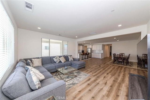 living room featuring recessed lighting, visible vents, and light wood-style flooring