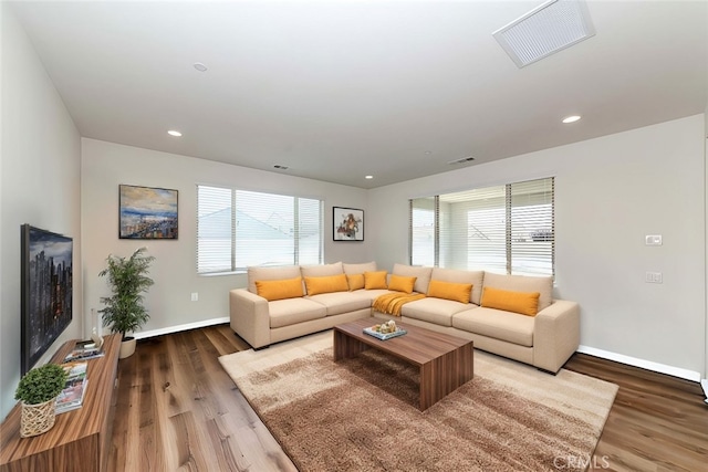 living area featuring recessed lighting, visible vents, baseboards, and wood finished floors