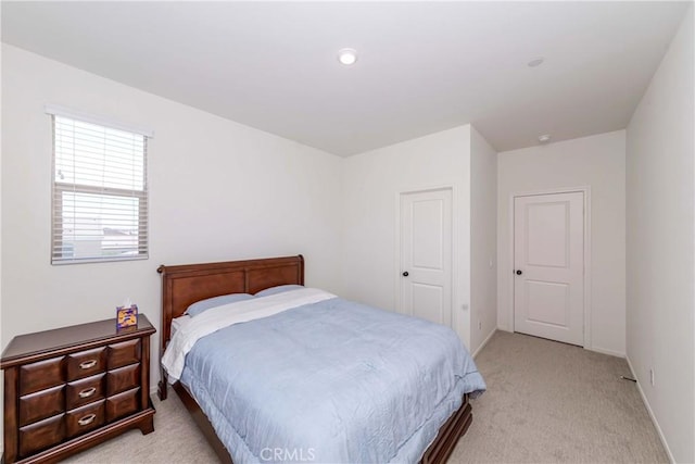 bedroom with light colored carpet and baseboards