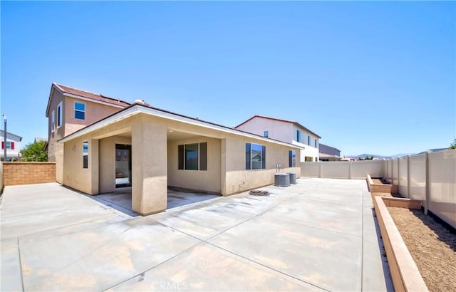 back of property with a patio area, stucco siding, and a fenced backyard