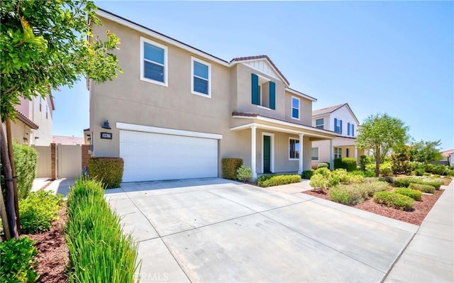 view of front of home with stucco siding, concrete driveway, a garage, and fence