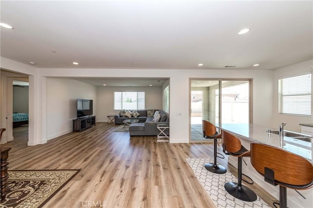 living room featuring recessed lighting, light wood-type flooring, and a wealth of natural light