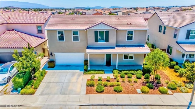 view of front of home with stucco siding, a residential view, driveway, and a tiled roof